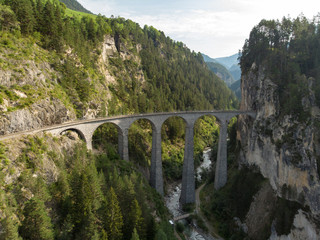 Fototapeta na wymiar Landwasser Viaduct / Switzerland - August 2018 - The Landwasser Viaduct is used by glacier express trains and popular place of taking photo by tourists. Aerial view