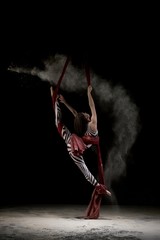Beautiful dancer on cloth in dust cloud