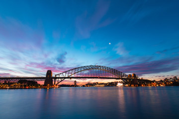 Colorful sky over Sydney Harbour Bridge at dusk.