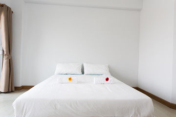 White bed in the white room with clear light from left side