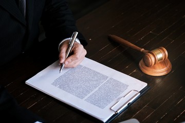 Legal counsel presents to the client a signed contract with gavel and legal law. justice and lawyer...