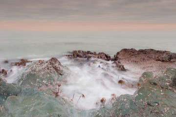 A beautiful scenery of wave splashing at the sunrise.