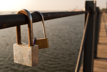 Candados en barandilla sobre puente de madera