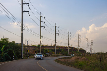Landscape nature of the way to go to the peak of mountain, Electricity pole on mountain with sunset sky clouds, Power transmission line in rural area