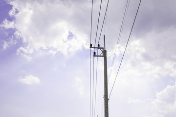 Electricity pole against blue sky clouds, Transmission line of electricity to rural with green...