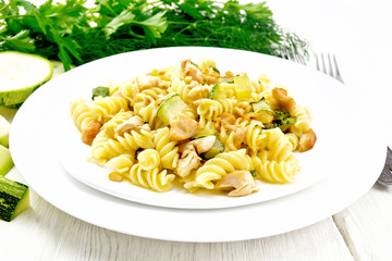Fusilli with chicken and zucchini in two plates on board
