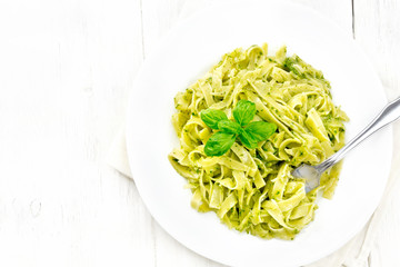 Pasta with pesto sauce in plate on board top