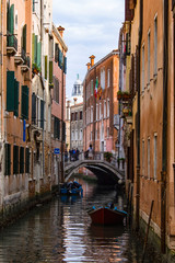 Traditional Venetian street with canal and bridge. Cityscape. Architecture and landmark of Venice, Italy.