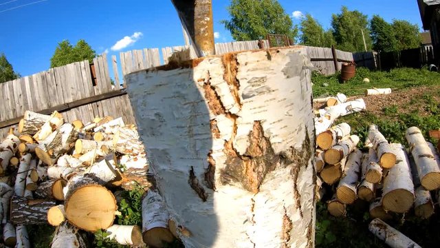 Man chopping wood with an ax.The process of harvesting wood.Strong blow.