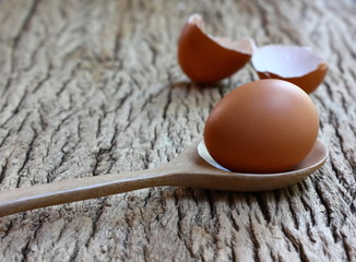 chicken egg with wood spoon on retor wood table background.