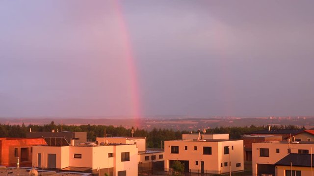 Suburban cityscape with a rainbow during sunset