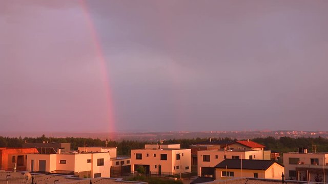 Suburban cityscape with a rainbow during sunset