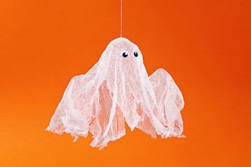Diy Halloween ghost of starch and gauze orange background. Gift idea, decor Halloween. Step by step
