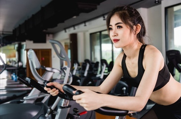 Fototapeta na wymiar Female lifestyle using equipment exercise bike for training cardio workout