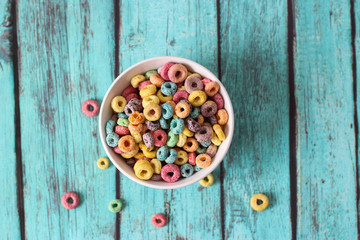 multicolored cereals in a white bowl on blue background