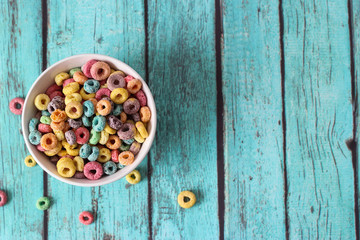 multicolored cereals in a white bowl on blue background
