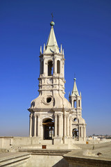Fototapeta na wymiar Stunning white volcanic stone bell tower of Basilica Cathedral of Arequipa against vibrant blue sky, Arequipa, Peru