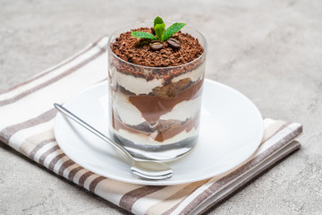 Classic tiramisu dessert in a glass on concrete background