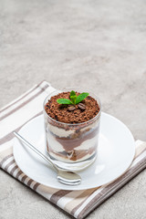 Classic tiramisu dessert in a glass on concrete background