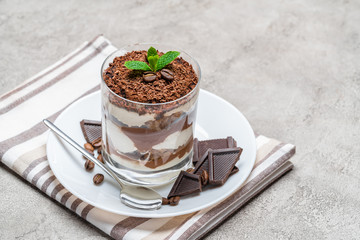 Classic tiramisu dessert in a glass on concrete background