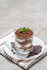 Classic tiramisu dessert in a glass on concrete background