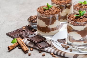 Classic tiramisu dessert in a glass on concrete background