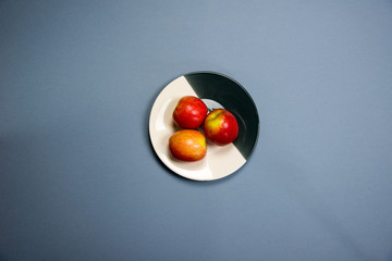 three apples on a plate