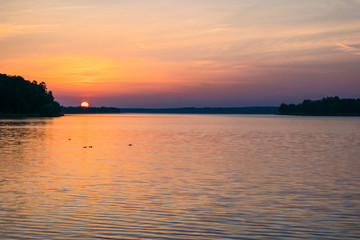 Fototapeta na wymiar Sunrises sunsets on a summer pond in the forest