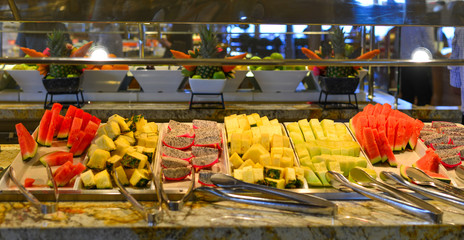 Plate with sliced fruits on servered buffet table