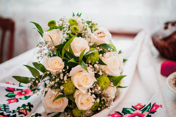 Bouquet of roses with golden wedding rings on it