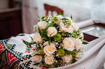 Bouquet of roses with golden wedding rings on it