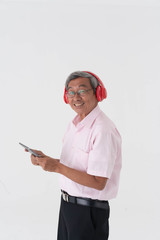 white studio portrait of senior asia retired elderly man wear red headphone listening music from tablet