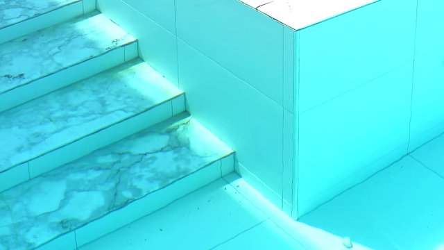 marble stair of swimming pool and wall tide under aqua color water