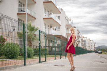 Naklejka premium Beautiful young woman blonde with long hair in a fashionable burgundy dress