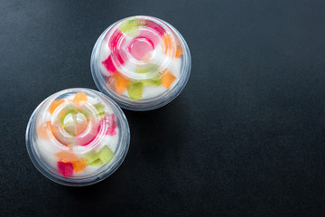 jelly in disposable glasses on a black table