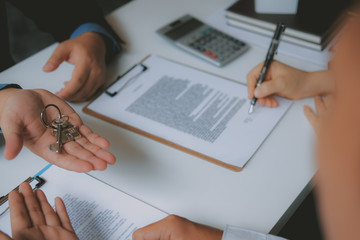 couple buying renting house signing mortgage contract agreement with realtor real estate agent.