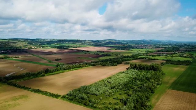 Aerial landscape forward shot of cloudy bright and shady view of agricultural areas hills and little forest summer zala county hungary europe