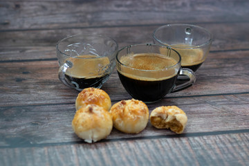 Cup of hot espresso coffee with Chinese Pastry or Thai Moon Cake on wooden board