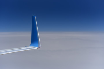 blue winglet on wing airplane in flying at high altitude