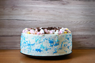 Large festive cake decorated with chocolate chips, marshmallows. Copy space for inscriptions.