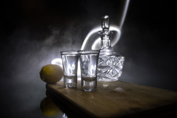 Club drink concept. Tasty alcohol drink cocktail tequila with lime and salt on vibrant dark background or glasses with tequila at a bar