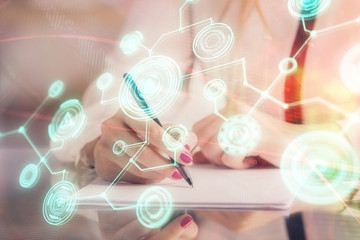 Social network theme hologram over hands taking notes background. Concept of global international people connect. Double exposure