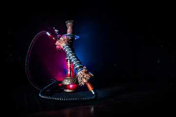 Hookah hot coals on shisha bowl on dark foggy background. Stylish oriental shisha.