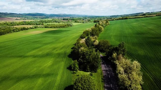 Aerial landscape shot of cloudy bright and shady view of agricultural areas hills following road summer zala county hungary europe
