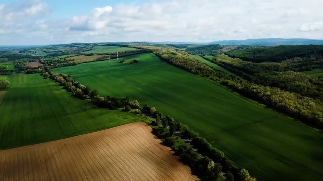 Aerial landscape slideling shot of cloudy bright and shady view of agricultural areas hills and little forest summer zala county hungary europe