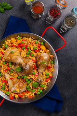 Arroz con pollo. Baked pieces of chicken with bone, rice with paprika and peas.