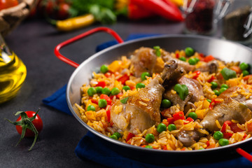 Arroz con pollo. Baked pieces of chicken with bone, rice with paprika and peas.