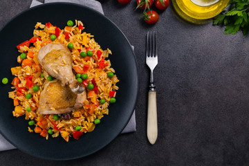 Arroz con pollo. Baked pieces of chicken with bone, rice with paprika and peas.