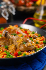 Arroz con pollo. Baked pieces of chicken with bone, rice with paprika and peas.