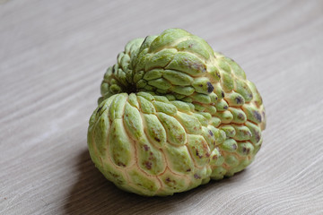 Obraz premium Sugar apple on on gray wooden floor background.
